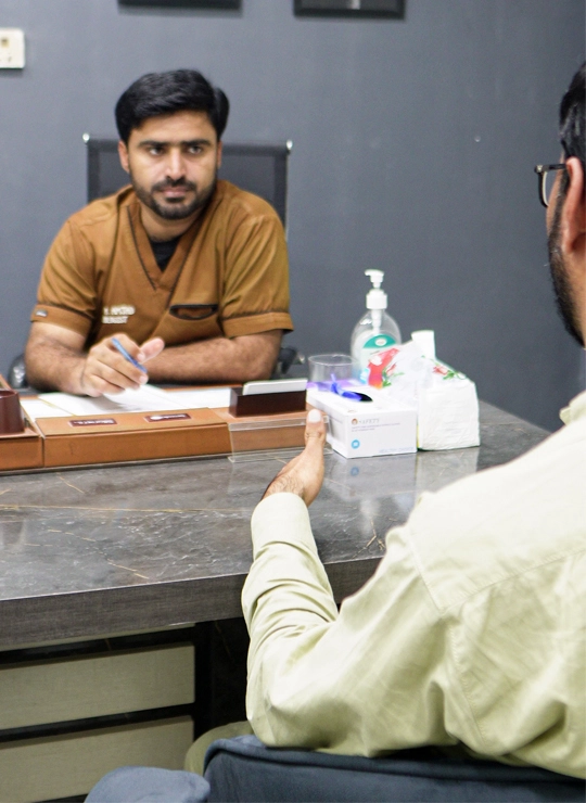 male health professional consulting for erectile dysfunction with patient at desk in clinical setting